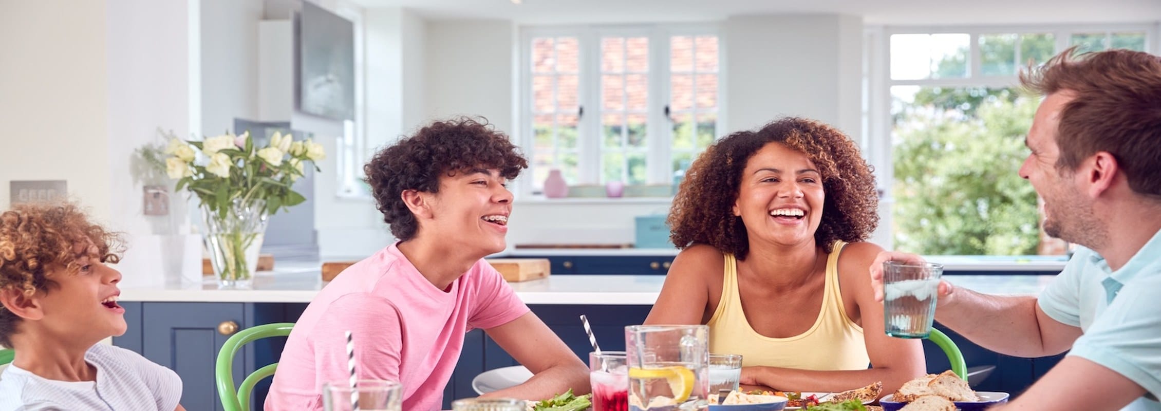 A real family talking and laughing together around the dinner table