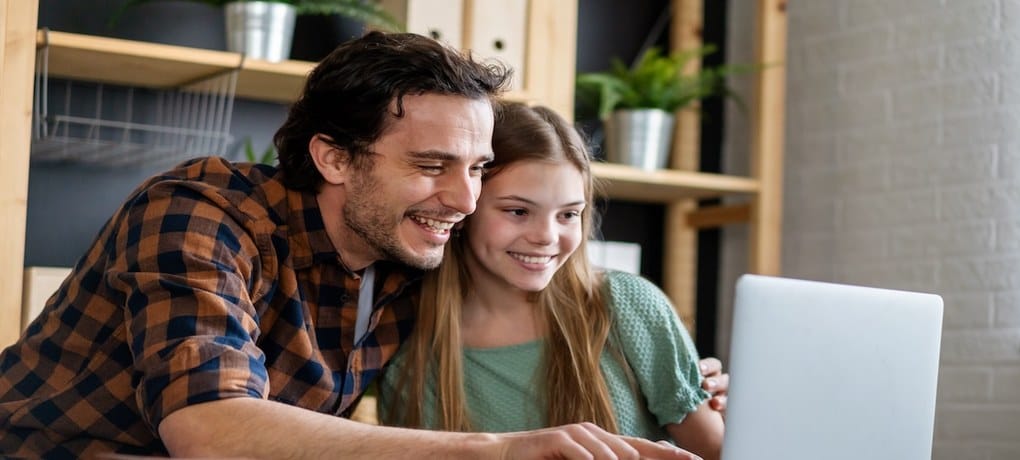 Parent and child looking at learning progress together on a laptop